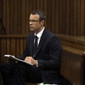 Olympic and Paralympic track star Oscar Pistorius takes notes during court proceedings at the North Gauteng High Court in Pretoria March 13, 2014.