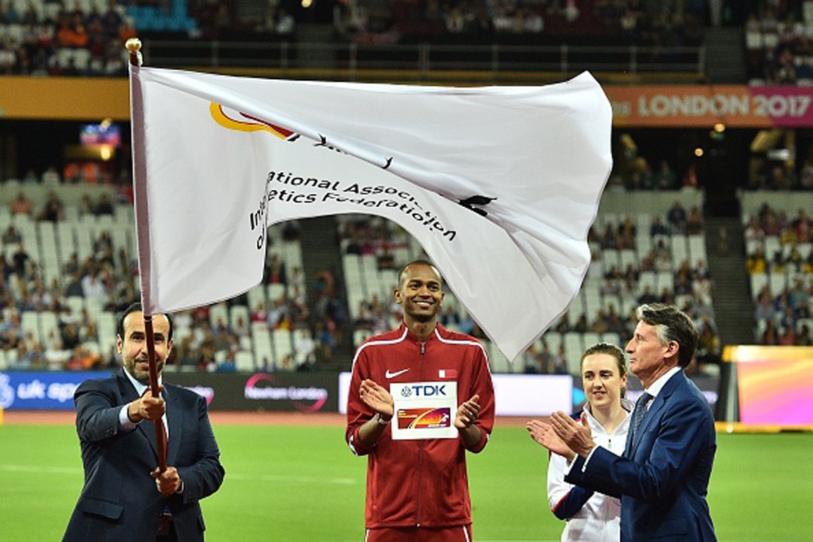 Dr Thani Al Kuwari, President of the QAF, receives IAAF flag from Lord Coe, President IAAF alongside Mutaz Barshim