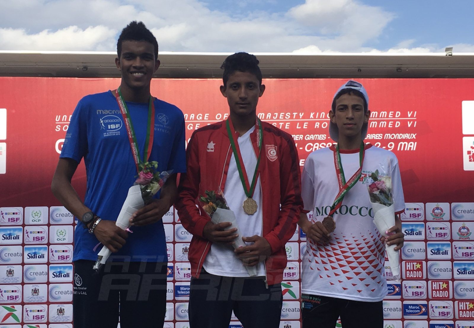 Tunisia's Ahmed Sayf Kadri (C) flanked by Portugal's Etson Barros and Mohamed Dahmouch of Morocco on the podium after the Boys 2000m Steeplechase medal presentation at Gymnasiade 2018 in Marrakech / Photo Credit: Yomi Omogbeja