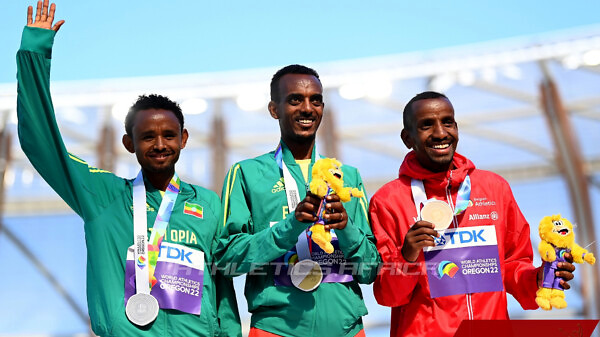 Ethiopia's Tamirat Tola flanked by compatriot Mosinet Geremew and Bashir Abdi on the podium for the men's marathon medal ceremony / Photo credit: Getty Images for World Athletics
